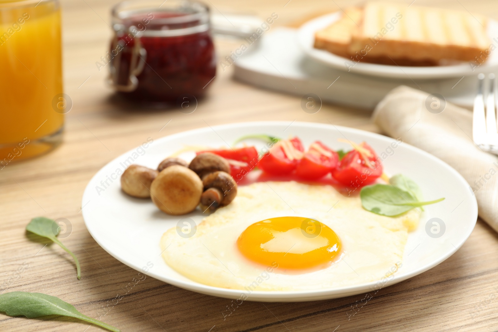 Photo of Tasty breakfast with fried egg on wooden table, closeup