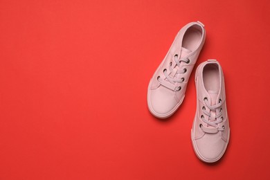 Photo of Pair of comfortable sports shoes on red background, flat lay. Space for text