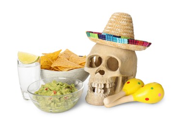 Photo of Mexican sombrero hat, human scull, maracas, tequila, nachos chips and guacamole in bowls isolated on white