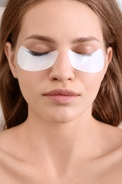 Young woman undergoing eyelash extensions procedure, closeup