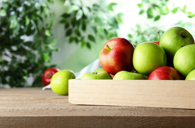 Ripe apples on wooden table against blurred background. Space for text