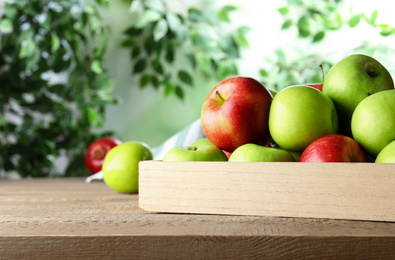 Photo of Ripe apples on wooden table against blurred background. Space for text