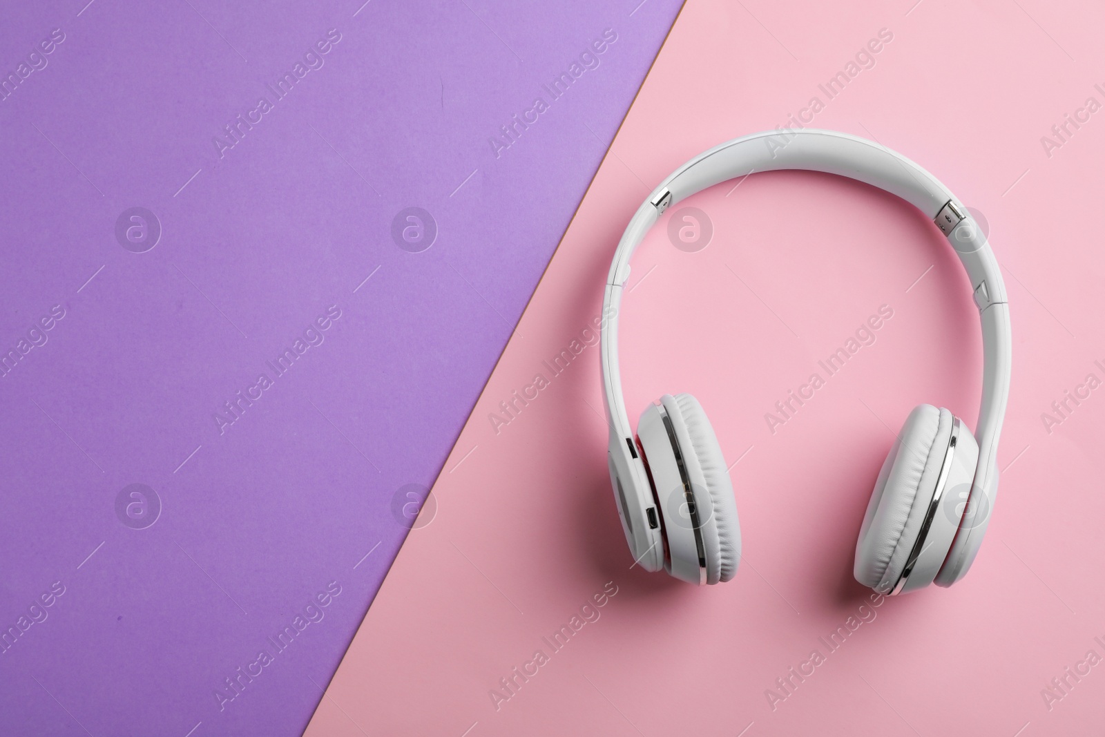 Photo of Wireless headphones on color background, top view. Space for text