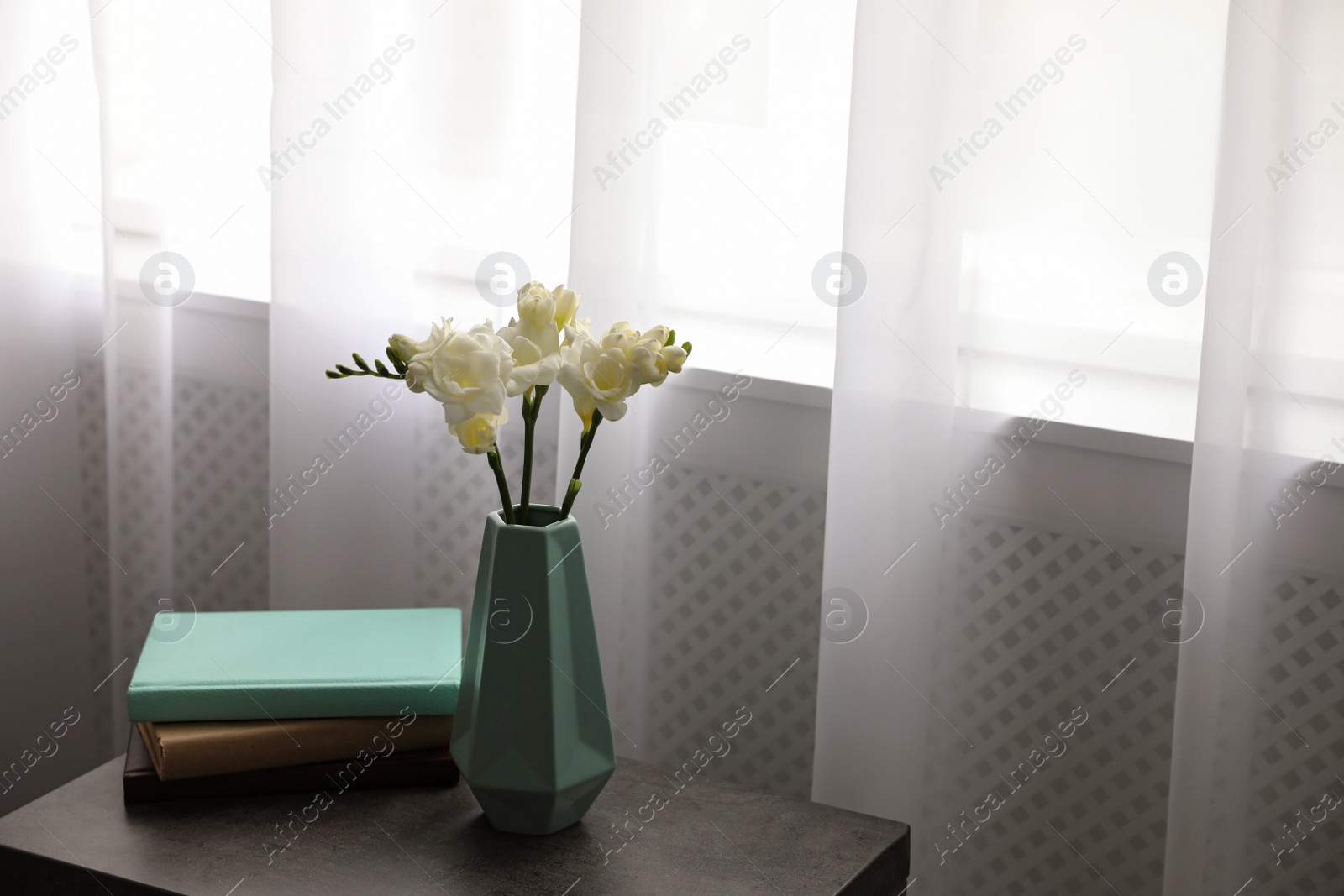 Photo of Beautiful spring freesia flowers on table in room