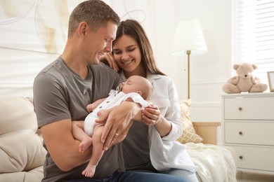 Happy couple holding their sleeping baby at home