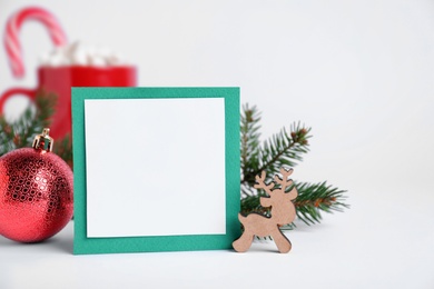 Photo of Blank Christmas card and festive decor on white background, space for text