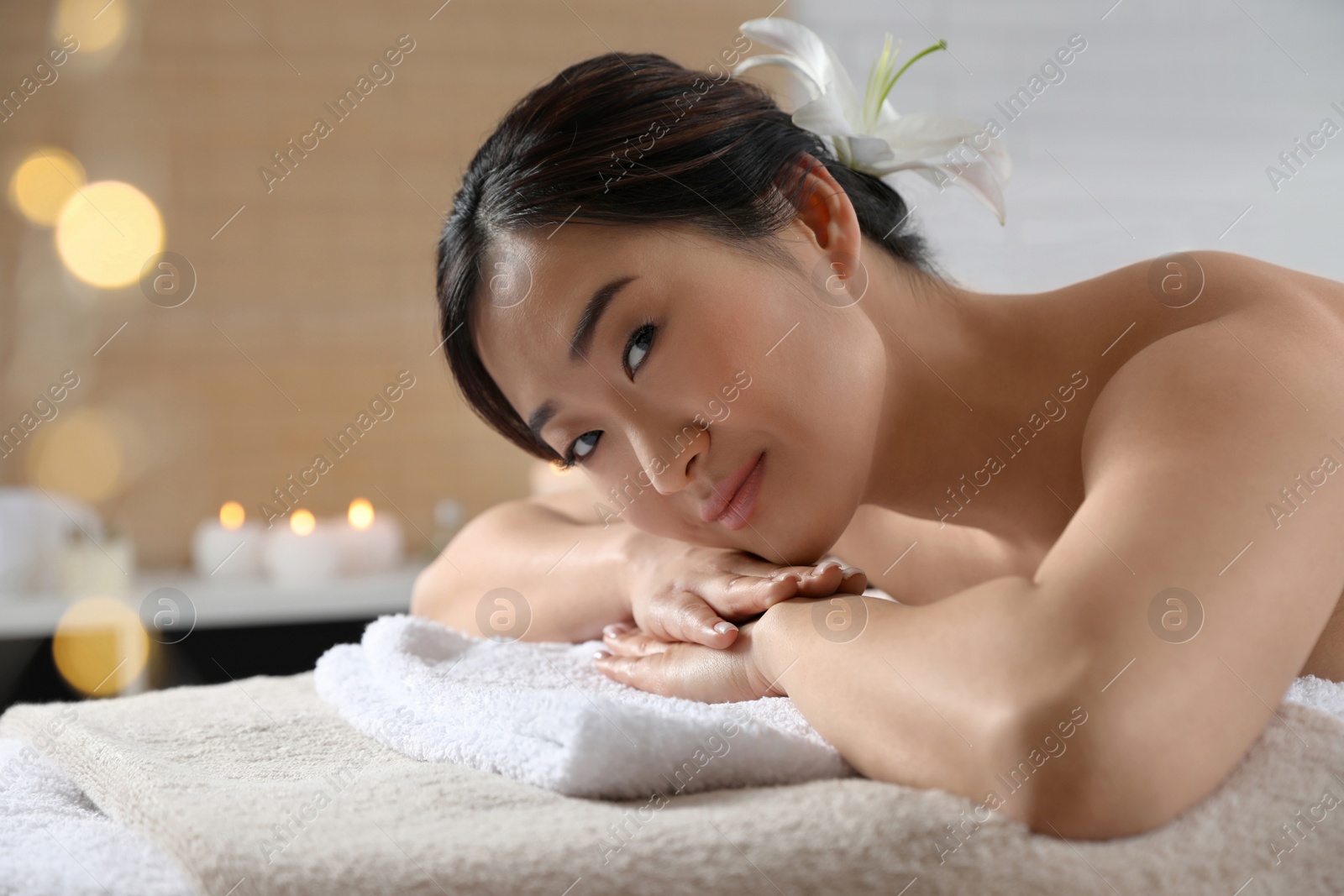 Photo of Beautiful Asian woman lying on massage table in spa salon