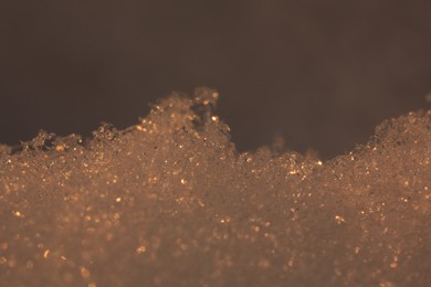 Photo of Shiny snow lit with sun at sunset, closeup