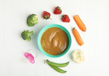 Flat lay composition with healthy baby food and ingredients on white wooden table