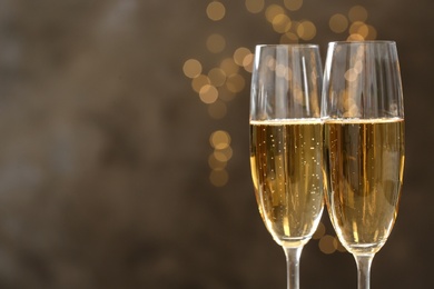 Photo of Glasses of champagne on blurred background, closeup. Space for text