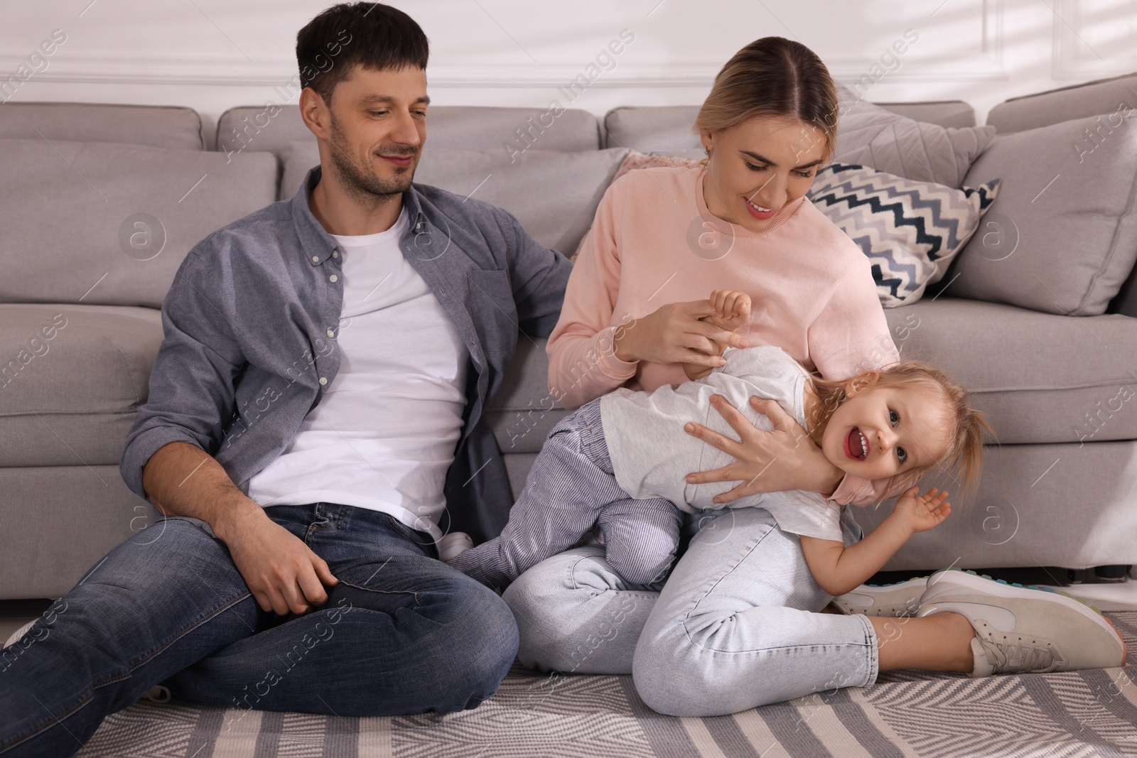 Photo of Family with little daughter spending time together at home