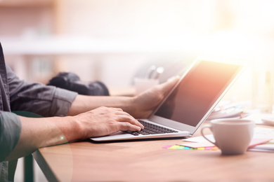 Image of Man working with laptop in office, closeup