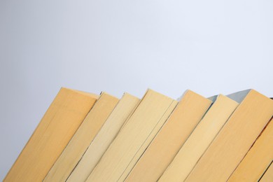 Photo of Collection of different books on light background, space for text