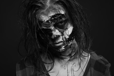 Scary zombie on dark background, black and white effect. Halloween monster