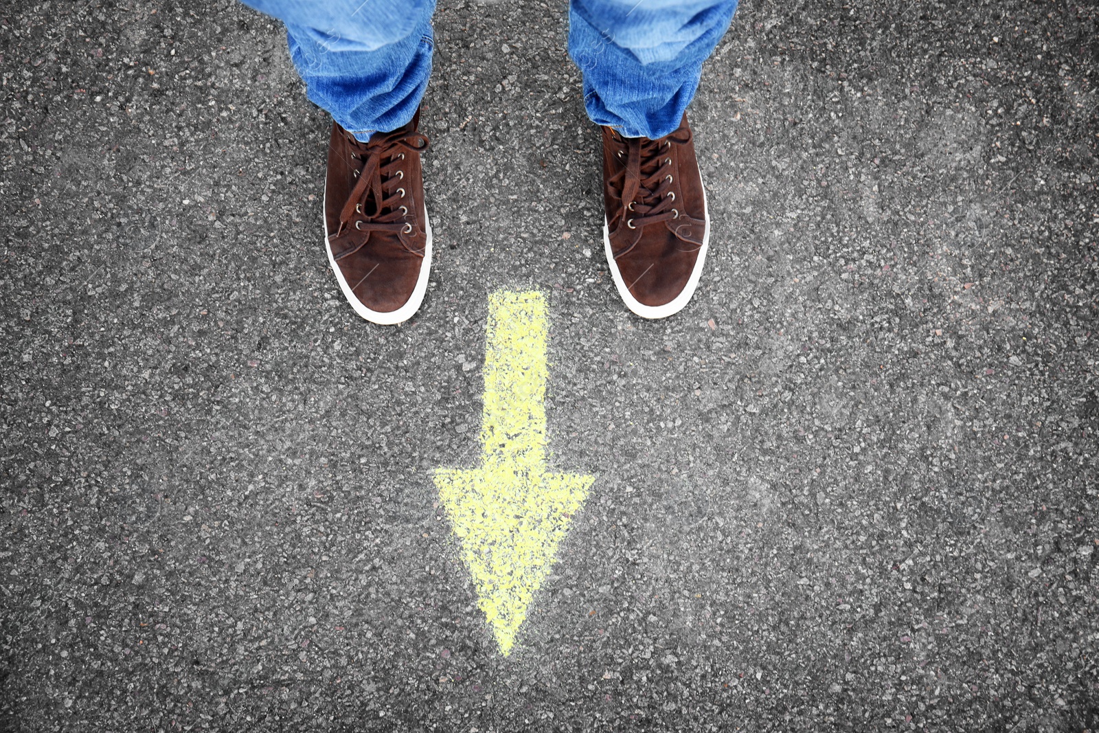 Photo of Man standing on road near arrow marking, closeup