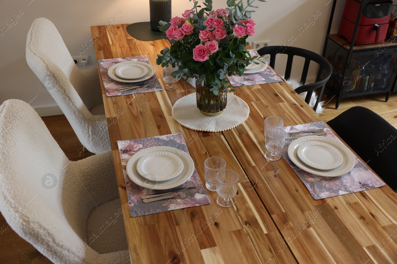 Photo of Beautiful table setting with bouquet indoors. Roses and eucalyptus branches in vase