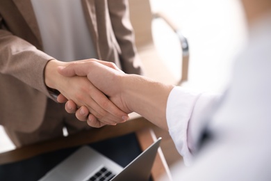 Business partners shaking hands after meeting, closeup