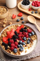Healthy muesli served with berries on wooden table