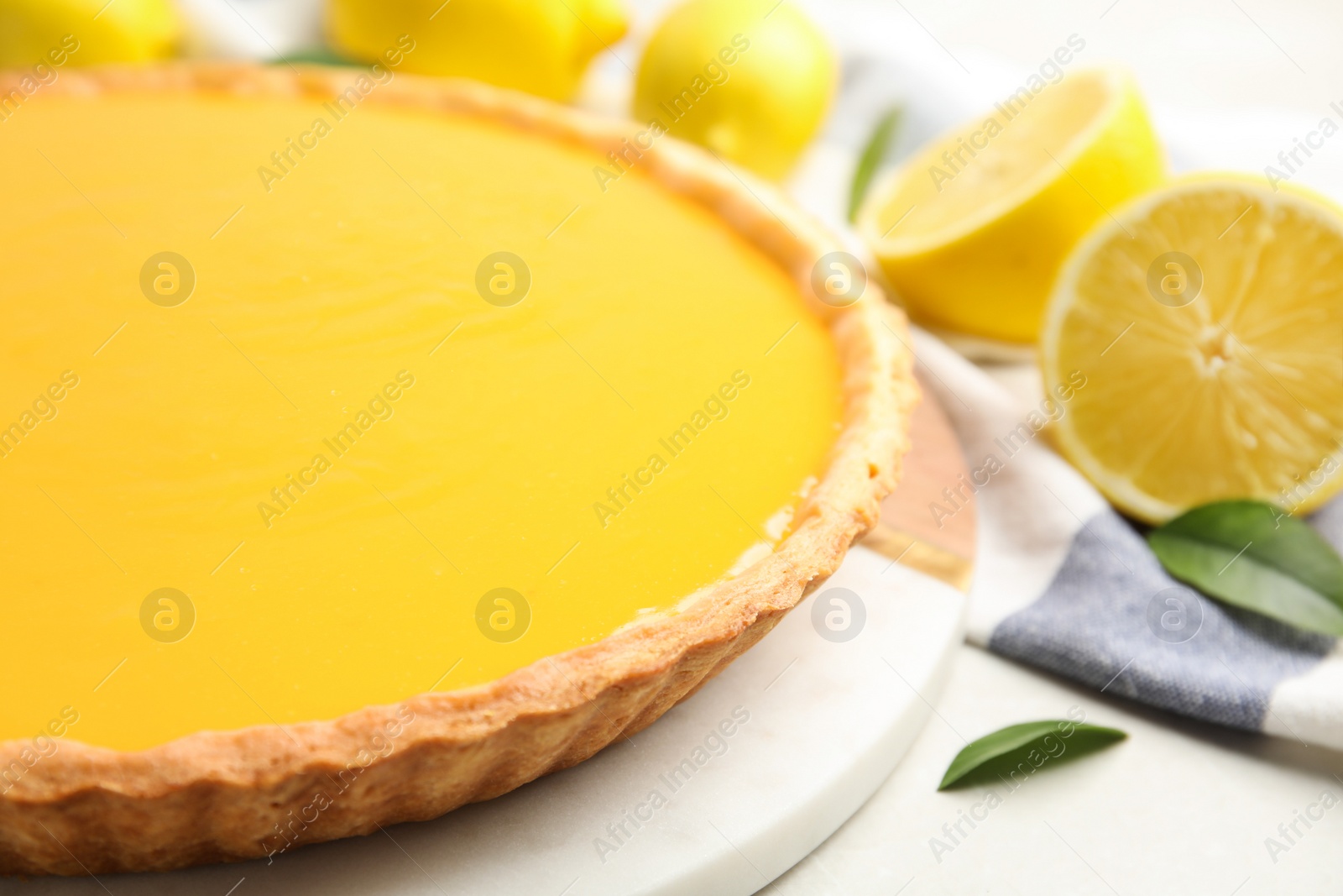 Photo of Delicious homemade lemon pie and fresh fruits on light table, closeup. Space for text