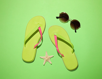 Flat lay composition with beach objects on green background