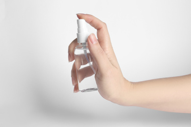 Photo of Woman holding antiseptic spray on white background, closeup