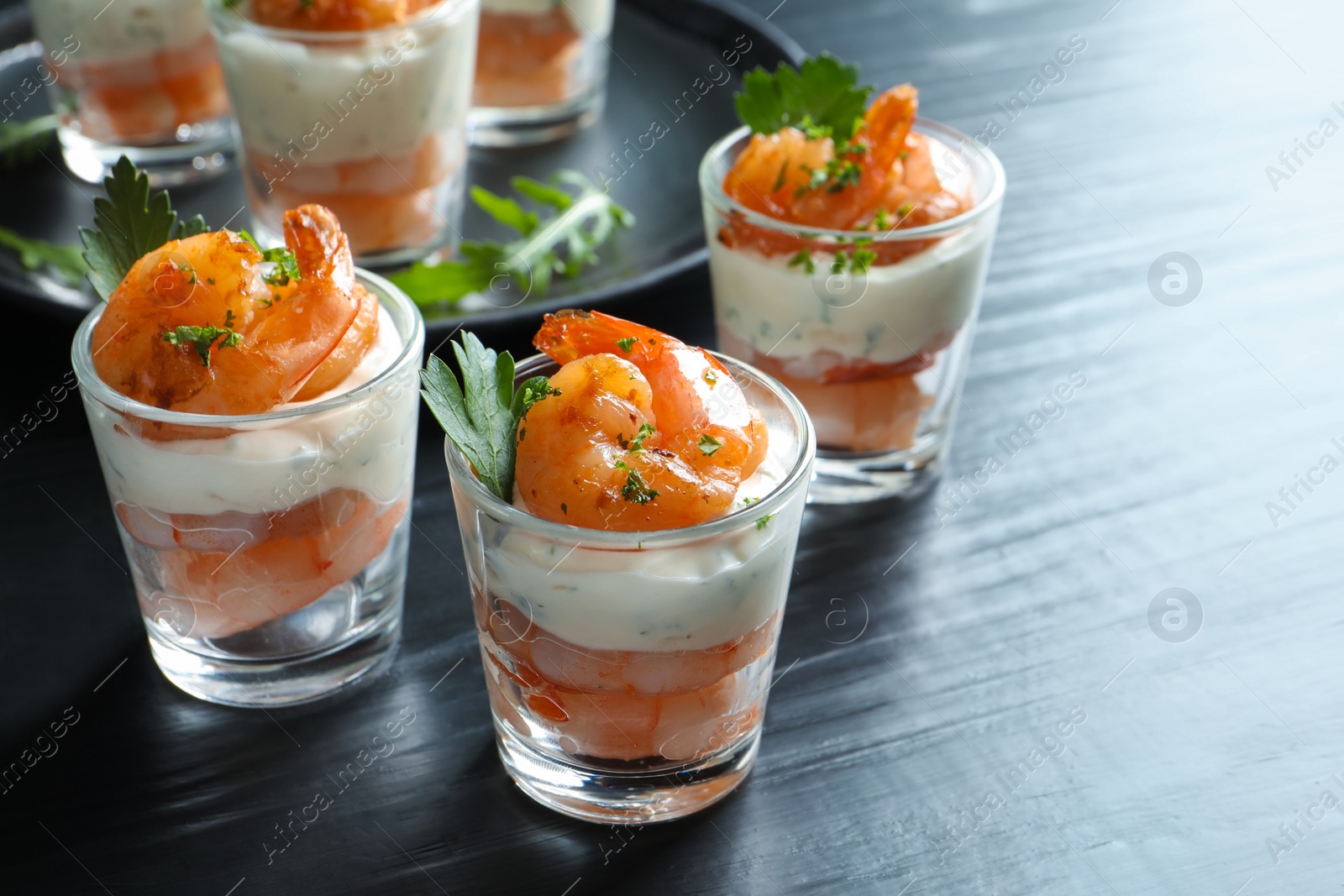 Photo of Glasses with fried shrimps and sauce on wooden background