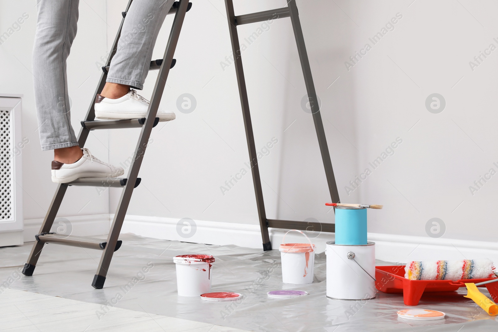 Photo of Young man climbing up ladder indoors, closeup