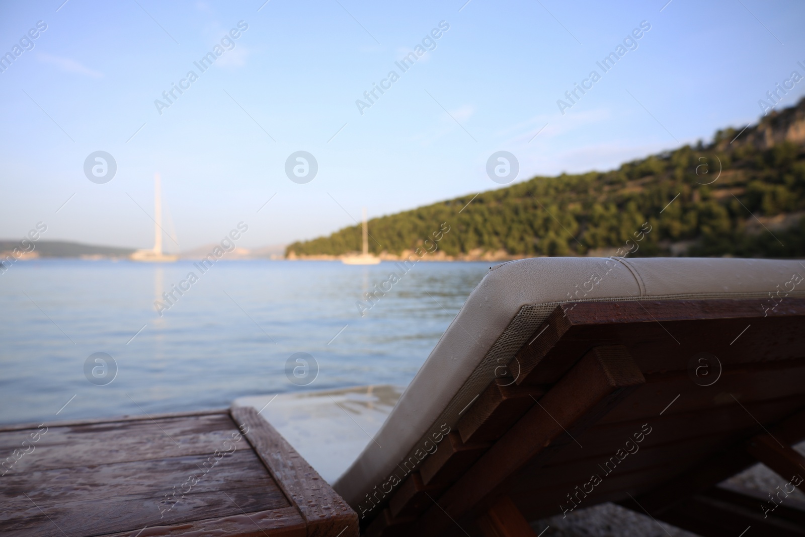 Photo of Beautiful view of seashore with sunbed on sunny day, closeup