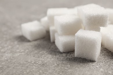 Photo of Many sugar cubes on gray table, closeup