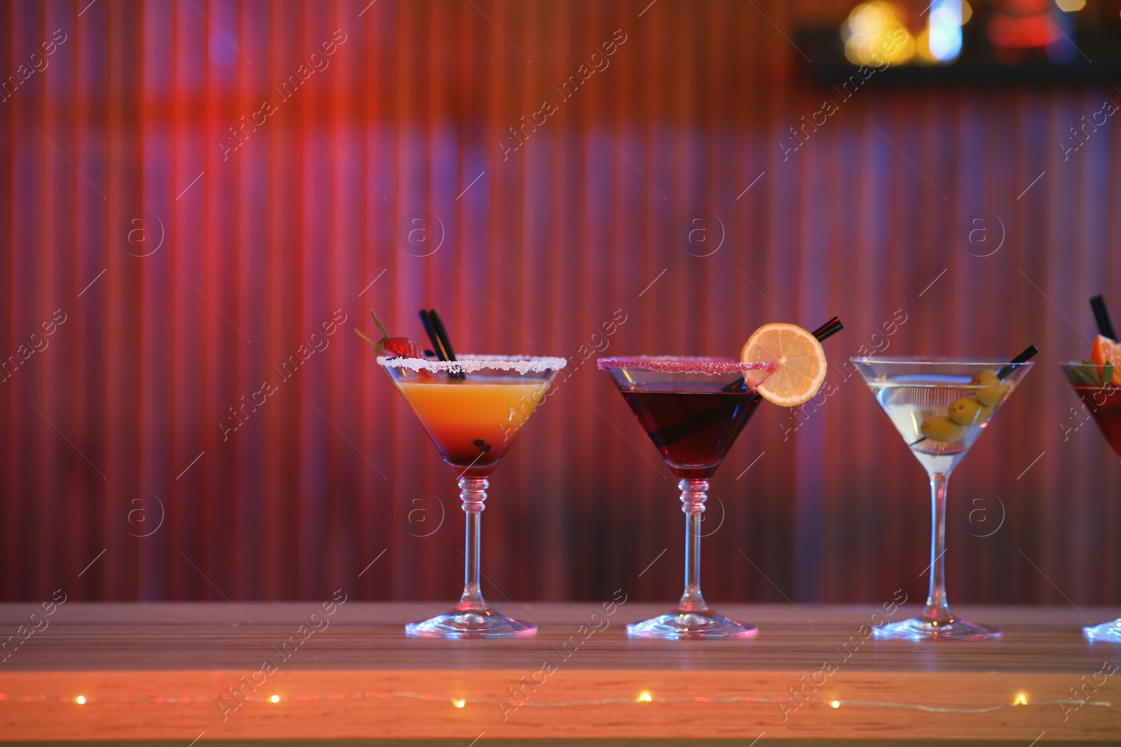 Photo of Different martini cocktails on table in bar, space for text