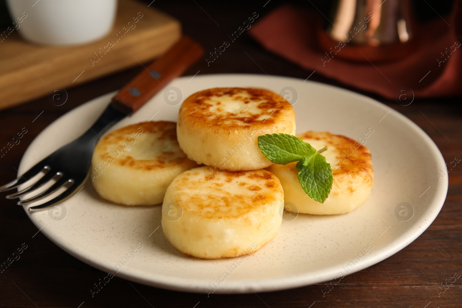 Photo of Delicious cottage cheese pancakes with mint on wooden table