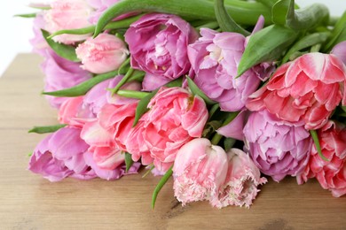 Beautiful bouquet of colorful tulip flowers on wooden table, closeup