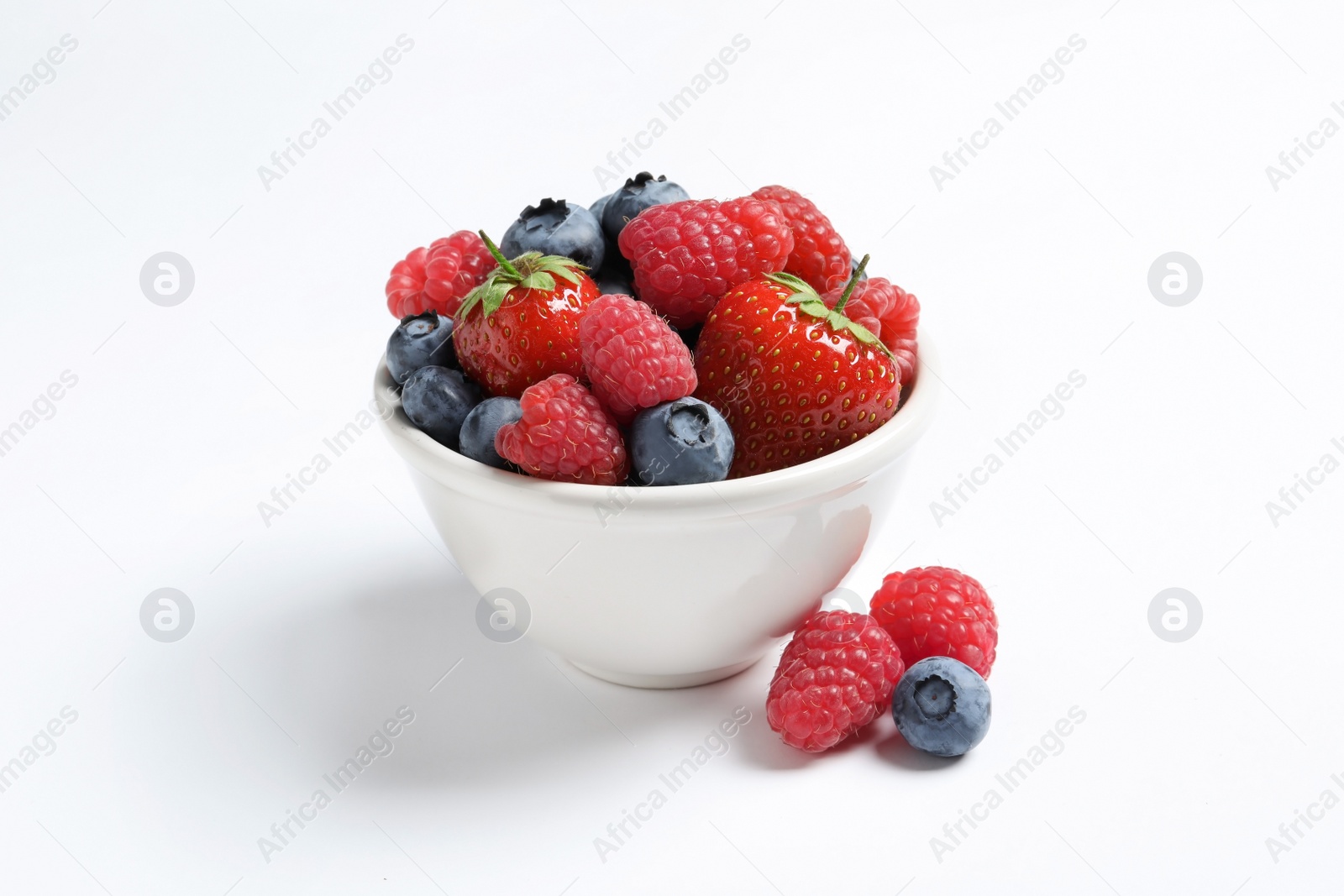 Photo of Bowl with raspberries, strawberries and blueberries on white background