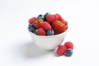 Photo of Bowl with raspberries, strawberries and blueberries on white background