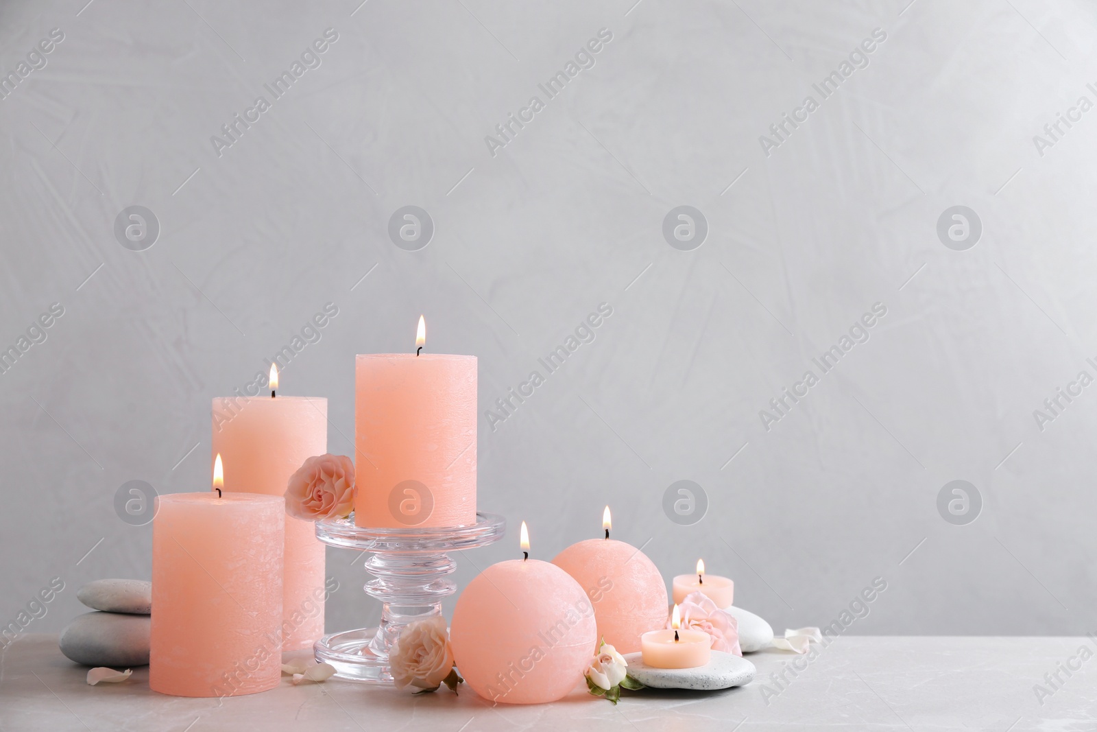 Photo of Beautiful composition with candles on table against grey background. Space for text