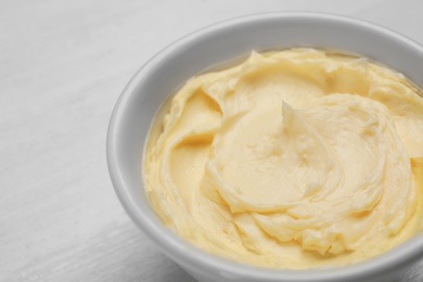 Bowl with tasty fresh butter on table, closeup