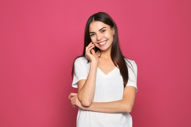 Portrait of young woman laughing on color background