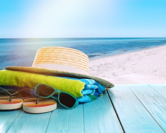 Beach accessories on turquoise wooden surface near ocean 