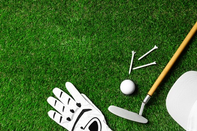 Photo of Flat lay composition with golf equipment on green course. Space for text