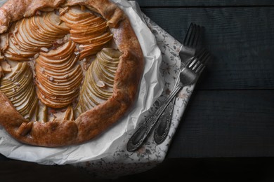 Photo of Delicious apple galette with walnuts and forks on wooden table, flat lay. Space for text