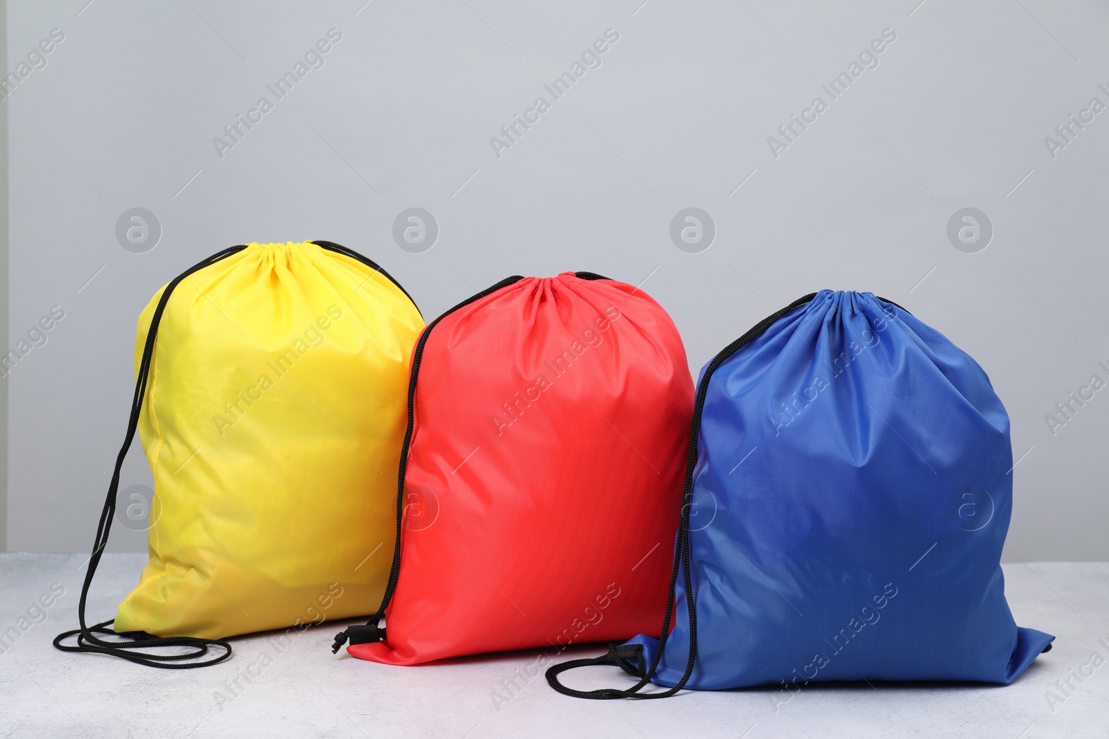 Photo of Bright drawstring bags on light textured table