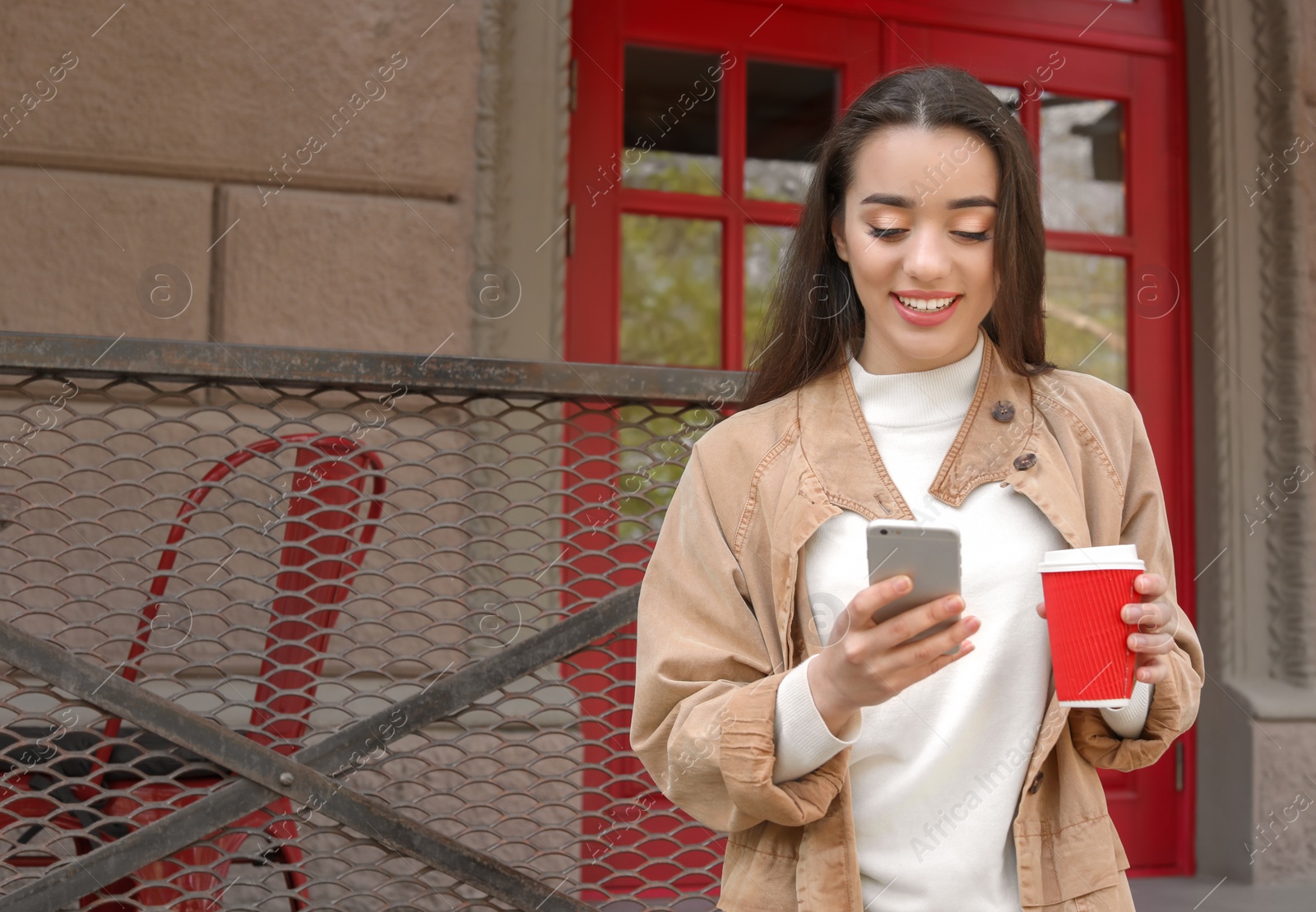 Photo of Young woman using mobile phone outdoors