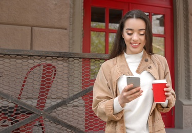 Photo of Young woman using mobile phone outdoors