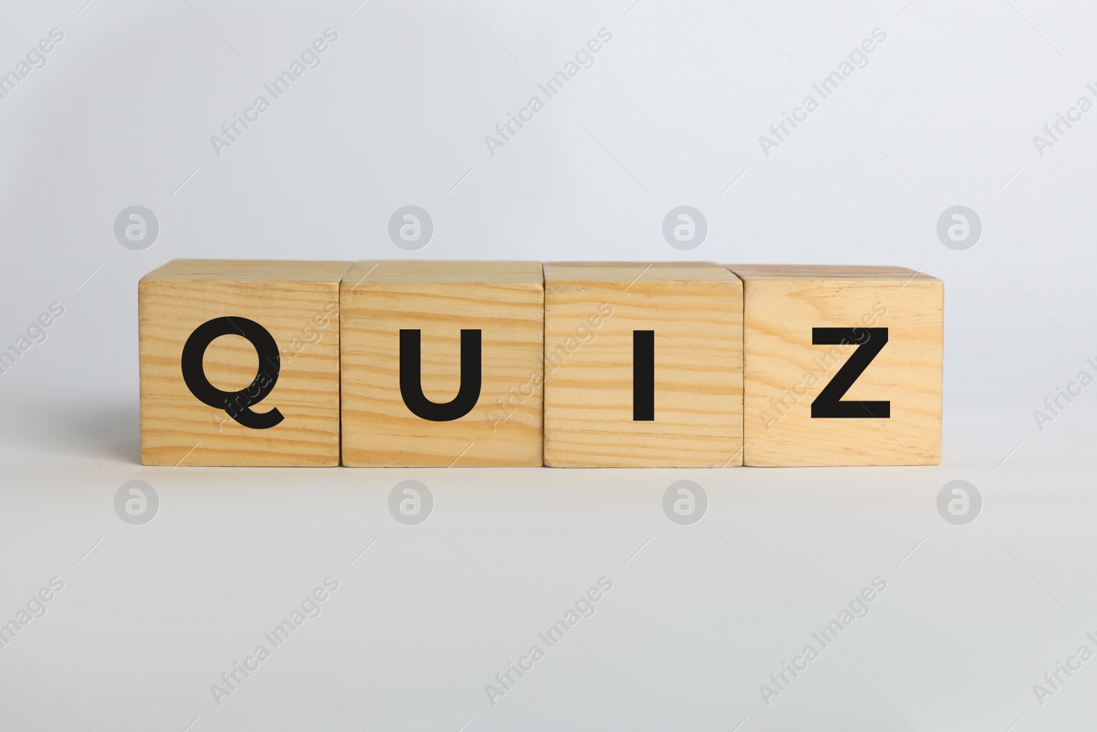 Photo of Wooden cubes with word Quiz on white background