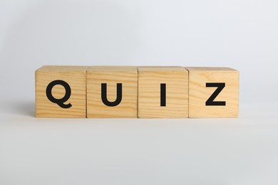 Wooden cubes with word Quiz on white background
