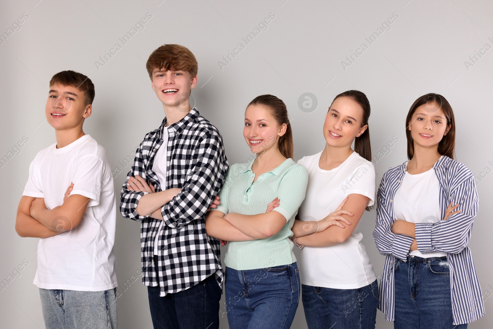 Photo of Group of happy teenagers on light grey background