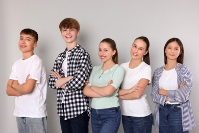 Group of happy teenagers on light grey background