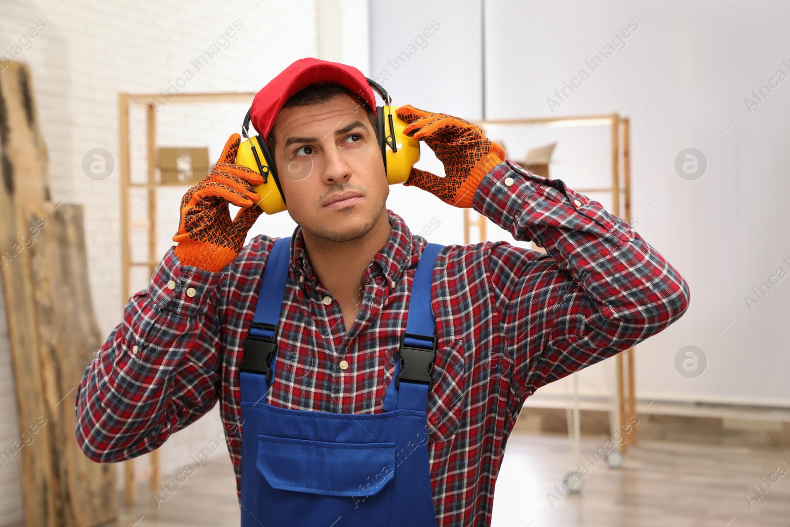 Photo of Worker wearing safety headphones indoors. Hearing protection device