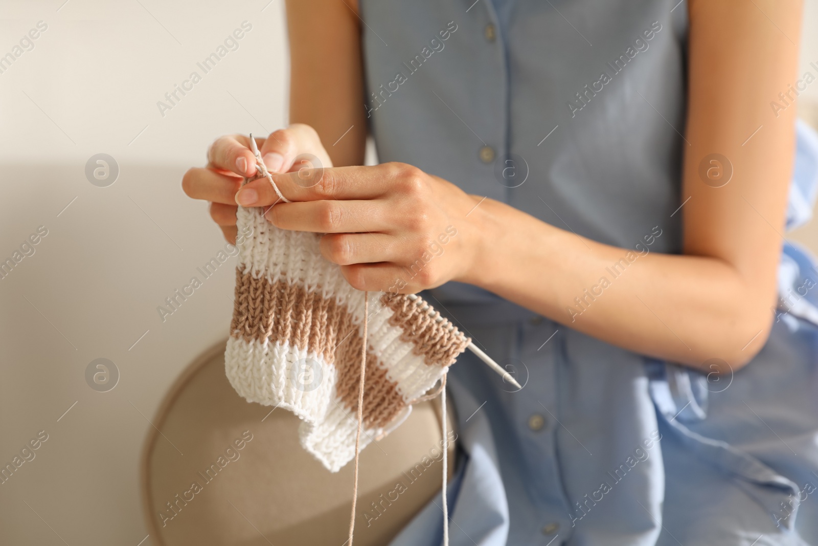 Photo of Young woman knitting with needles at home, closeup. Handicraft as hobby