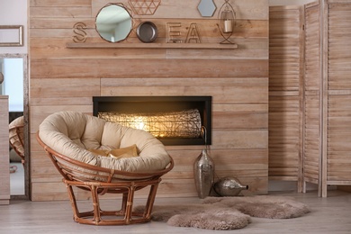 Cozy living room interior with comfortable papasan chair and decorative fireplace